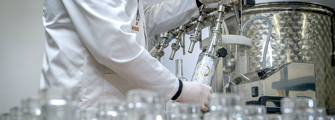 A photo of someone filling up bottles of gin