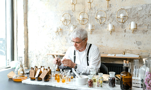 Man creating products at a desk by mixing oils